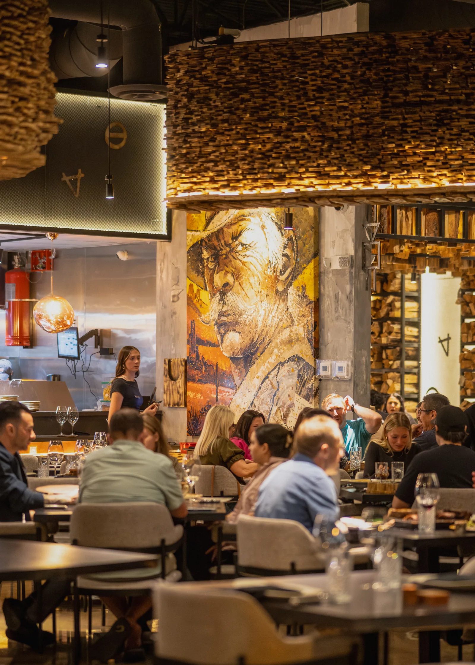 Warm wood details, artwork and guests in the Origen Gilbert dining room.